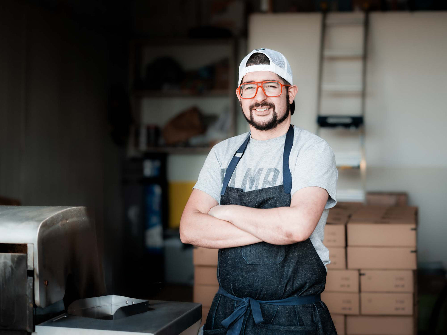 Owner Homero smiling, standing with crossed arms in the garage